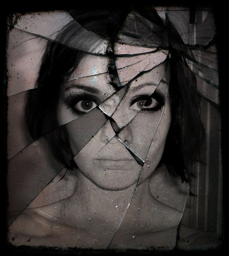 black and white image of woman behind broken glass
