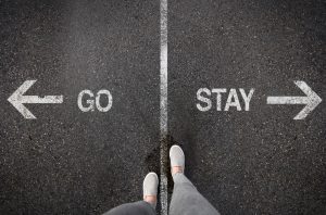 person standing at go or stay sign representing the difference between healing and avoiding